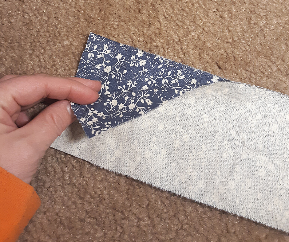 2 strips of blue fabric with white flowers, with right sides together, for the 1 hour apron apron tie