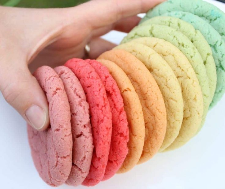 a hand holding rainbow cookies