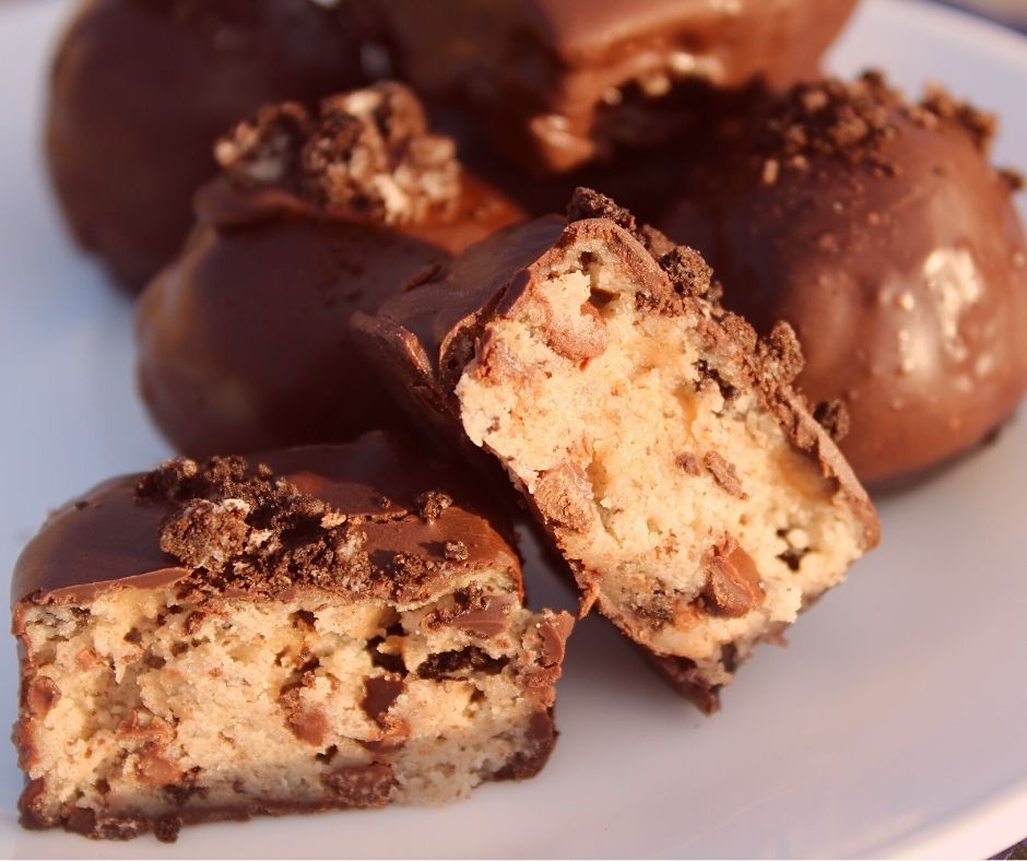 eggless cookie dough balls, covered in chocolate on a white plate