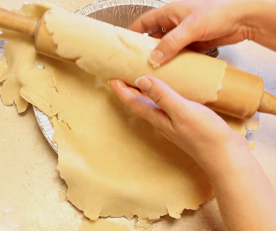 easy pie crust being unrolled onto a pie pan