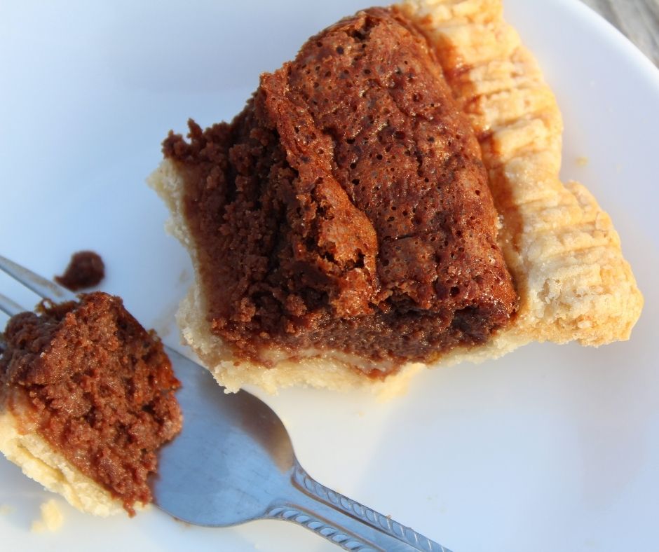 a slice of chocolate chess pie with easy pie crust with a bite taken out of it