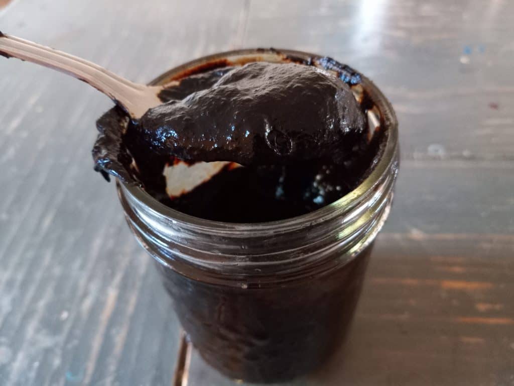 Texas Persimmon pudding in a mason jar with a spoon
