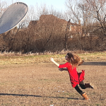 a girl leaping for a giant flying frisbee for a fun family activity