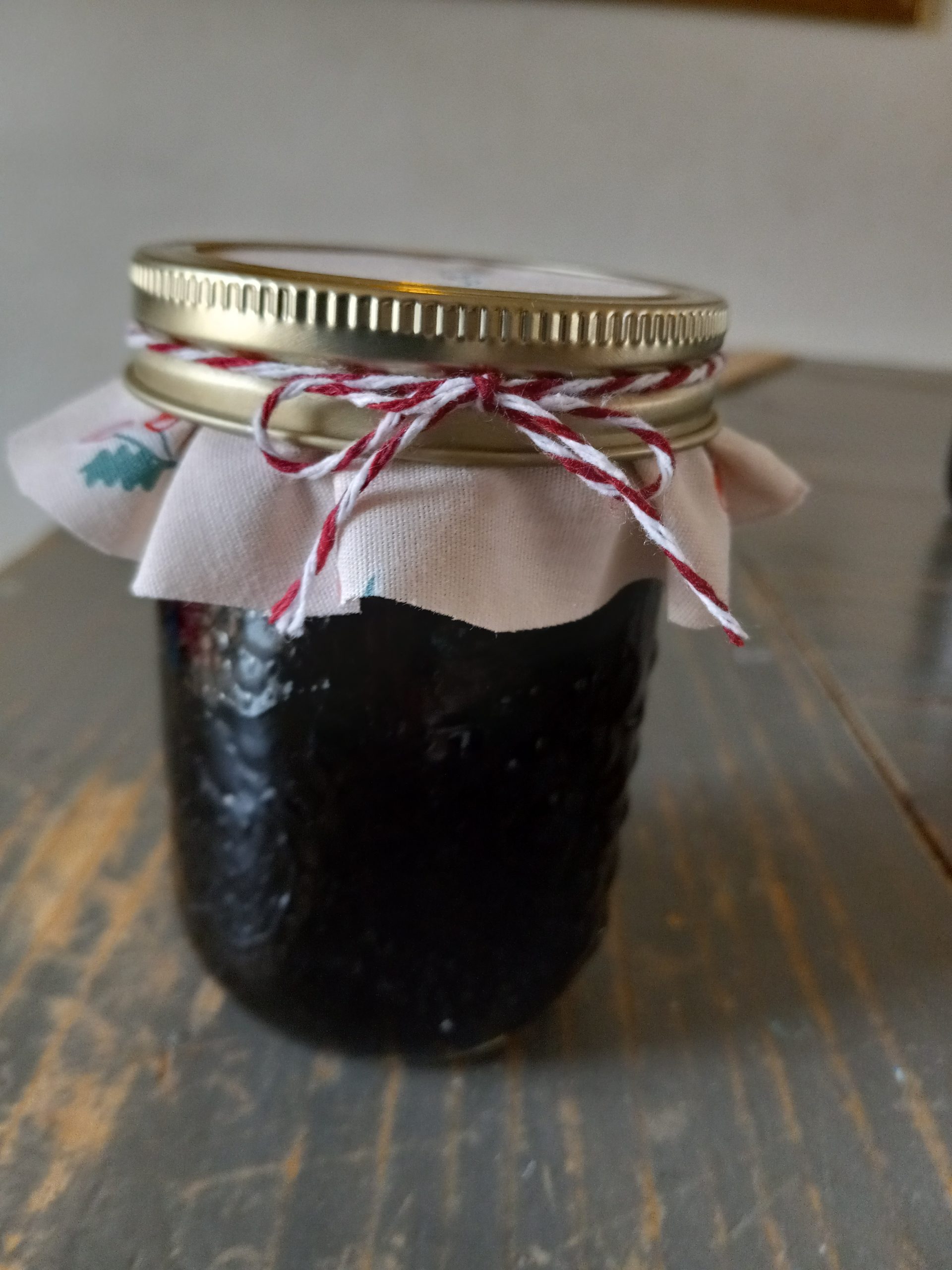texas persimmon jam in a jar with fabric and twine