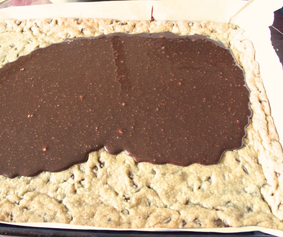 frosting being spread on the chocolate chip cookie bars